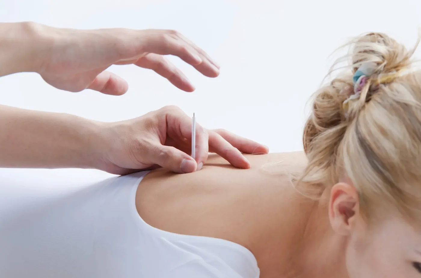 Dr. Yasmin Harounian L.Ac performing electroacupuncture treatment in her Los Angeles clinic